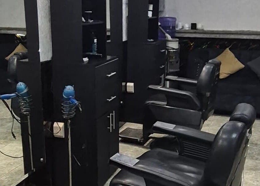 Salón moderno de Elegante en Manta, Manabí, EC con sillas de peluquería y secadores profesionales.