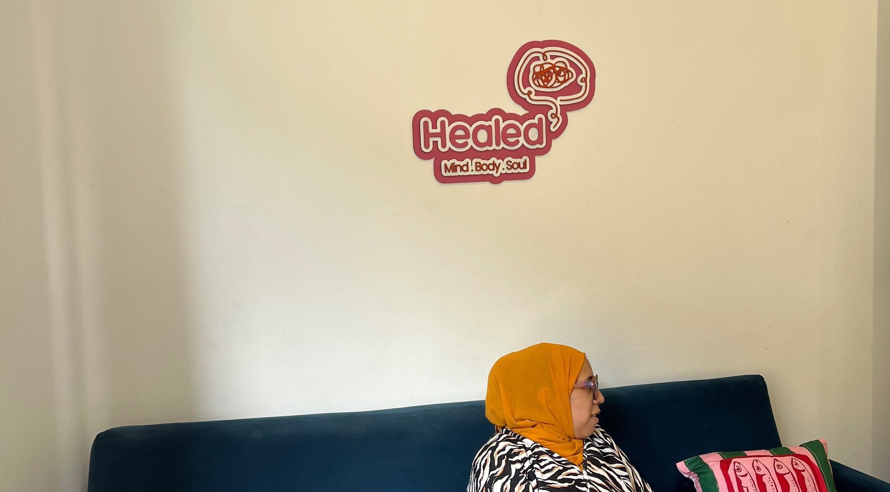 Woman in orange headscarf relaxing in the Healed lounge, Cape Town, Western Cape, ZA.