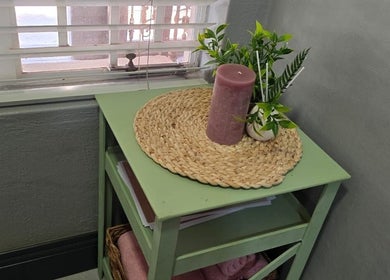 Decorative table with pink candle and greenery at Leoné Scheepers Beauty, Pretoria, Gauteng, ZA.