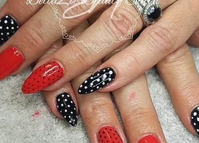 Red and black polka dot nails at BellaZoe Nail Salon, klerksdorp, ZA, showcasing creative nail art.