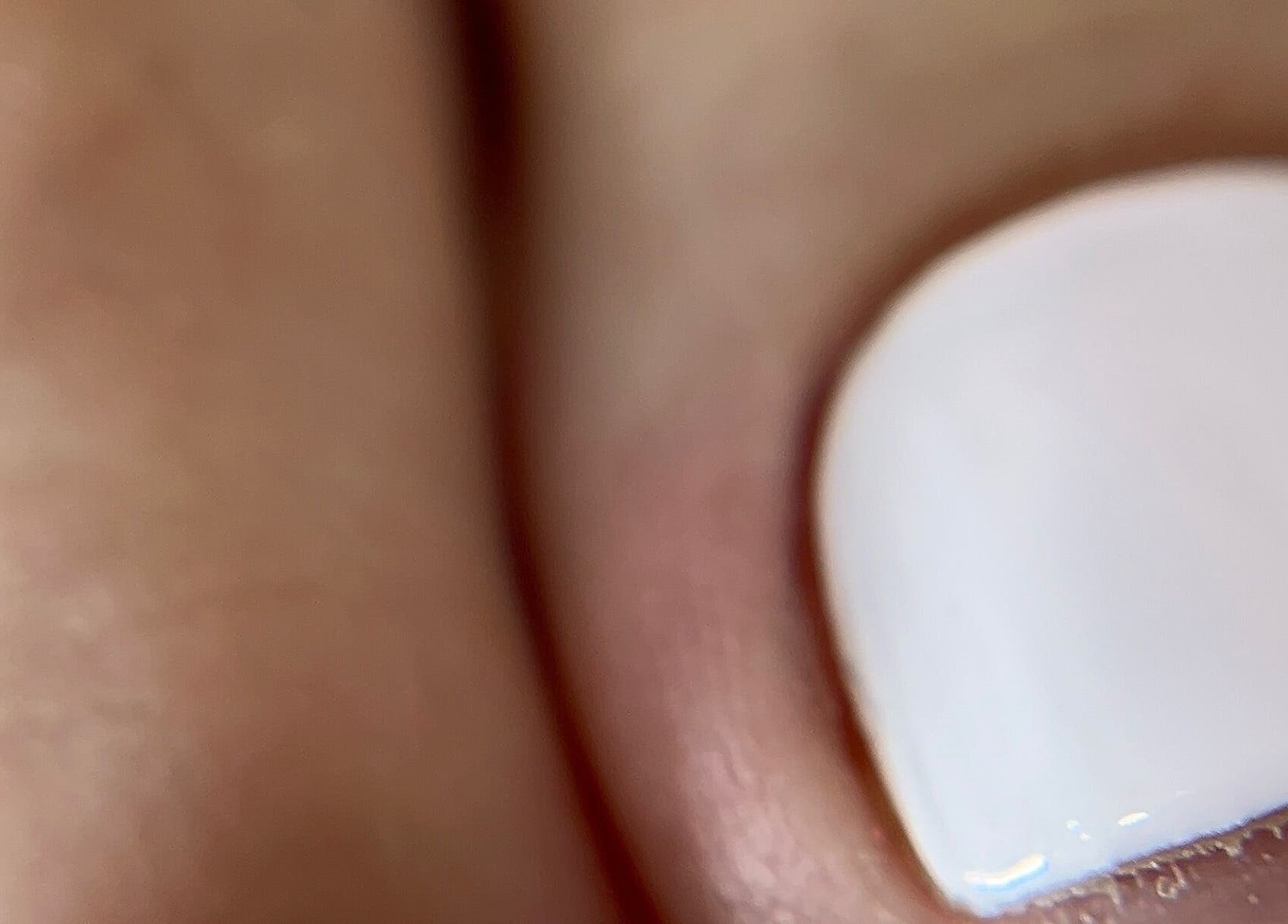 Close-up of a manicured nail with white polish at Eri F Beauty, Rio Tinto, Porto, PT.