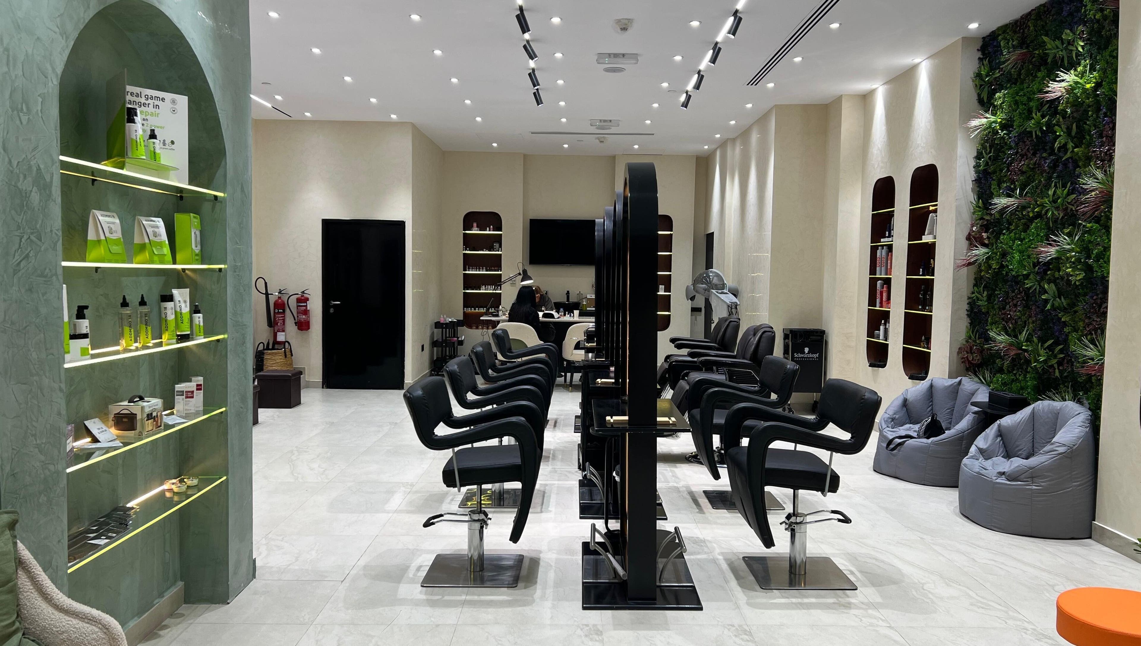 Interior of Gaia Beauty Lounge in Dubai, AE, showcasing modern hair stations and lush green decor.