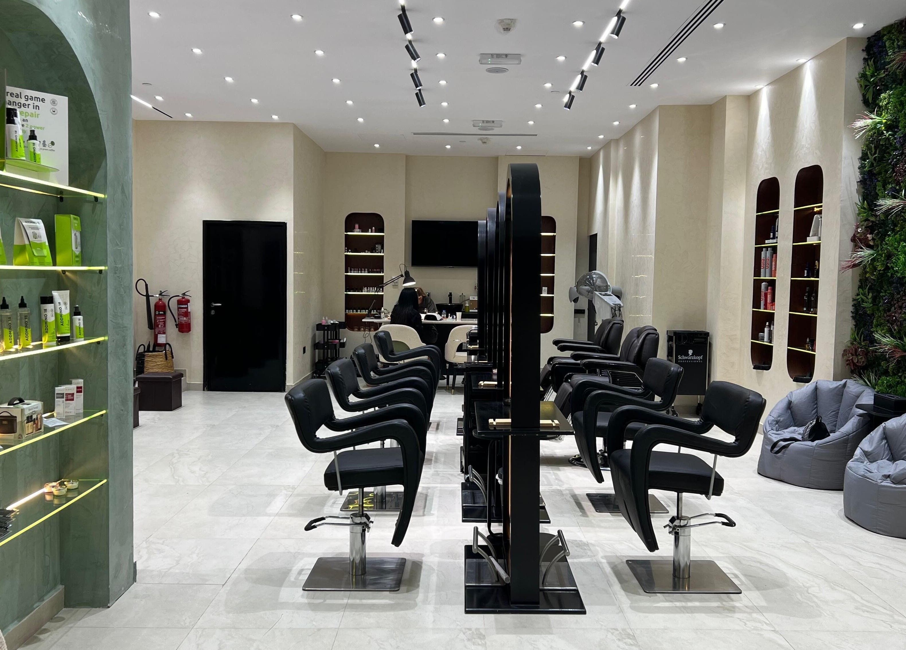 Interior of Gaia Beauty Lounge in Dubai, AE, showcasing modern hair stations and lush green decor.