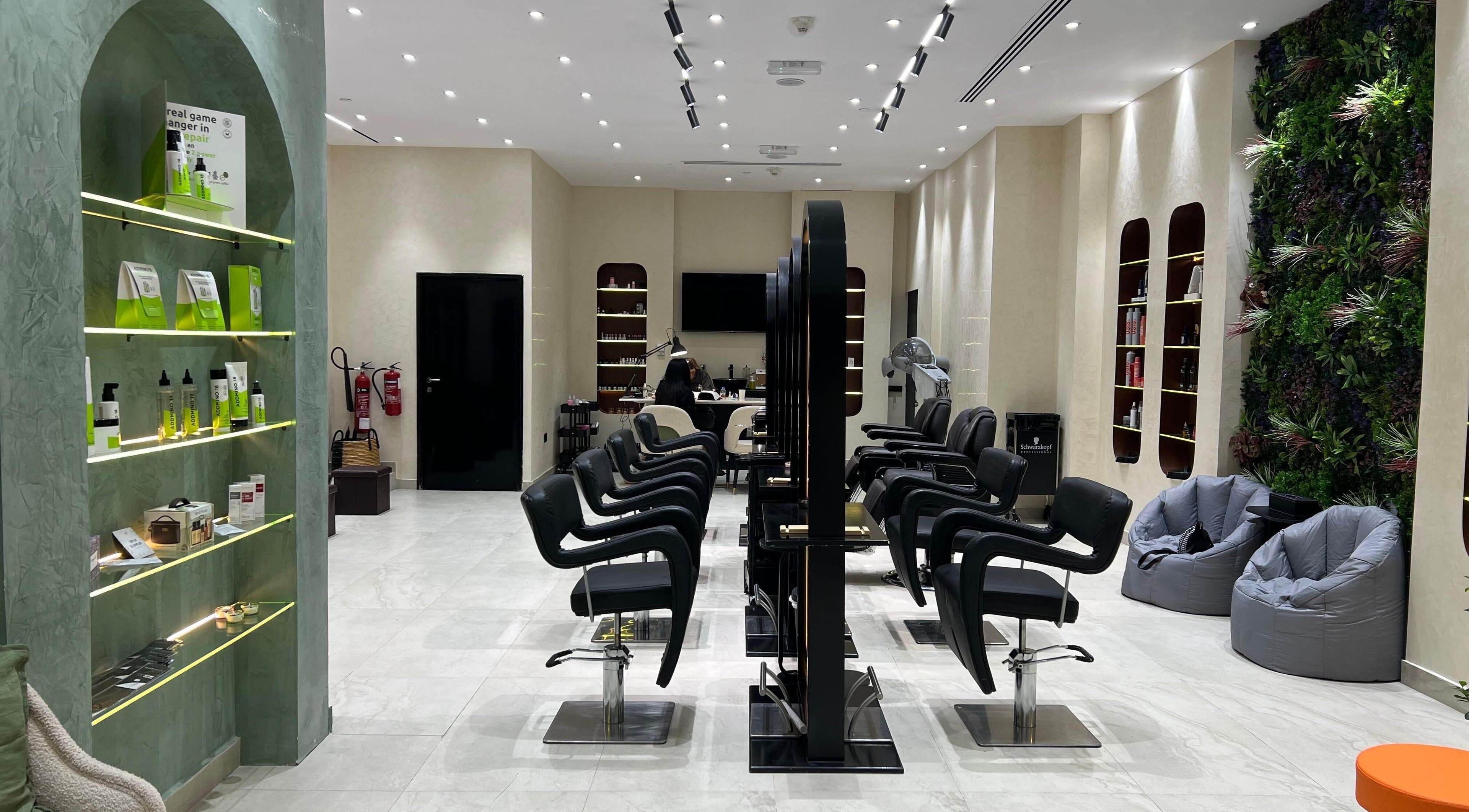 Interior of Gaia Beauty Lounge in Dubai, AE, showcasing modern hair stations and lush green decor.