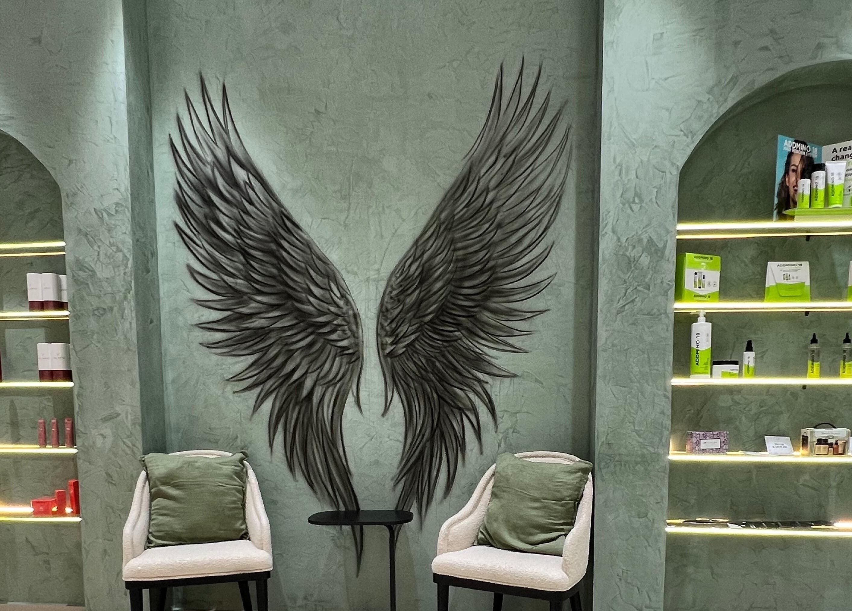 Chic interior at Gaia Beauty Lounge, Dubai, with angel wing decor and product shelves.