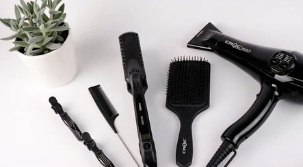 Salon tools at Sleeks Salon in Toronto, Ontario, CA feature a hair dryer, brushes, and plant.