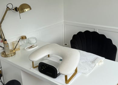 Elegant nail station at ByChlo in Morley, England, GB, featuring a gold lamp and plush black chair.