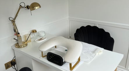 Elegant nail station at ByChlo in Morley, England, GB, featuring a gold lamp and plush black chair.