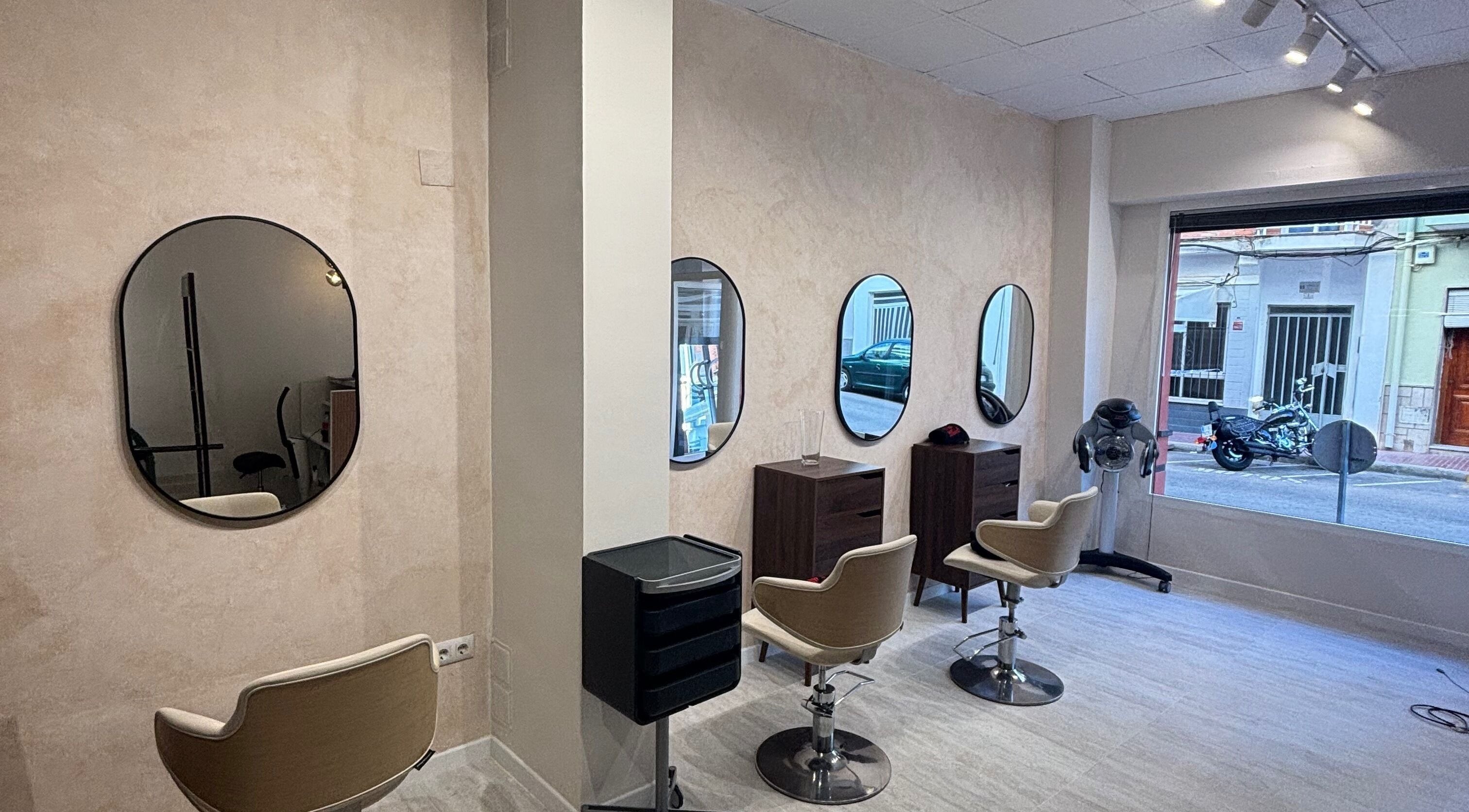 Interior moderno de Yūgen by Mireia en Piles, Comunidad Valenciana, ES, mostrando espejos elegantes y sillas de salón.