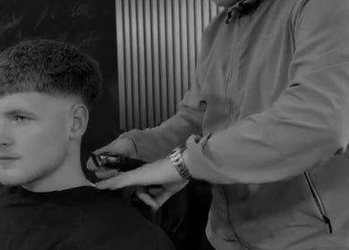 Barber styling a man's hair with clippers at Twinz Trimz, Kilmarnock, Scotland, GB.