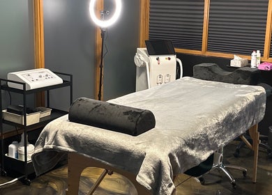 Cozy treatment room at Studio Carine | Laser & Peau, Longueuil, Québec, CA with spa table and modern equipment.