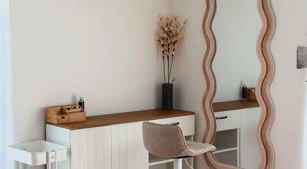 Элегантный уголок в Romashka Beauty Room, Кашкайш, Лиссабон, ПТ, с волнистым зеркалом и стильной мебелью.