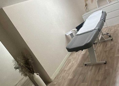 A tranquil treatment room at Bychloeleigh in Wales, GB, featuring a massage table and minimalist decor.