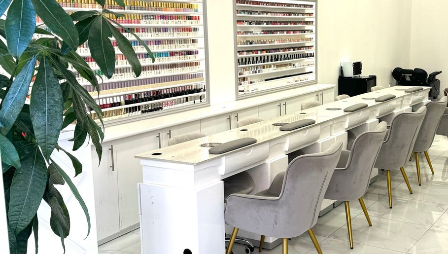 Elegant nail salon interior at Moon Beauty, London, England, GB showcasing plush seating and polish display.