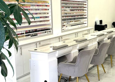 Elegant nail salon interior at Moon Beauty, London, England, GB showcasing plush seating and polish display.