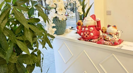 Inviting reception at Moon Beauty, London, England, GB with decorative lucky cats and orchids.