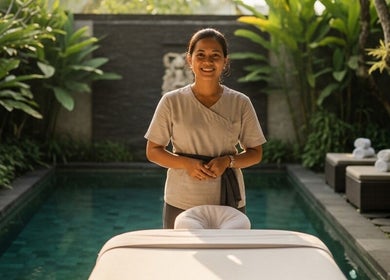 Massage therapist at ELEXOIR HOME MASSAGE SERVICE UBUD, Bali, Bali, ID, near a pool with lush greenery.