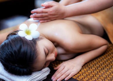Ontspannen lichaamsmassage bij Weena Thai Massage Therapy, Gent, Vlaanderen, BE, met bloem op hoofd.