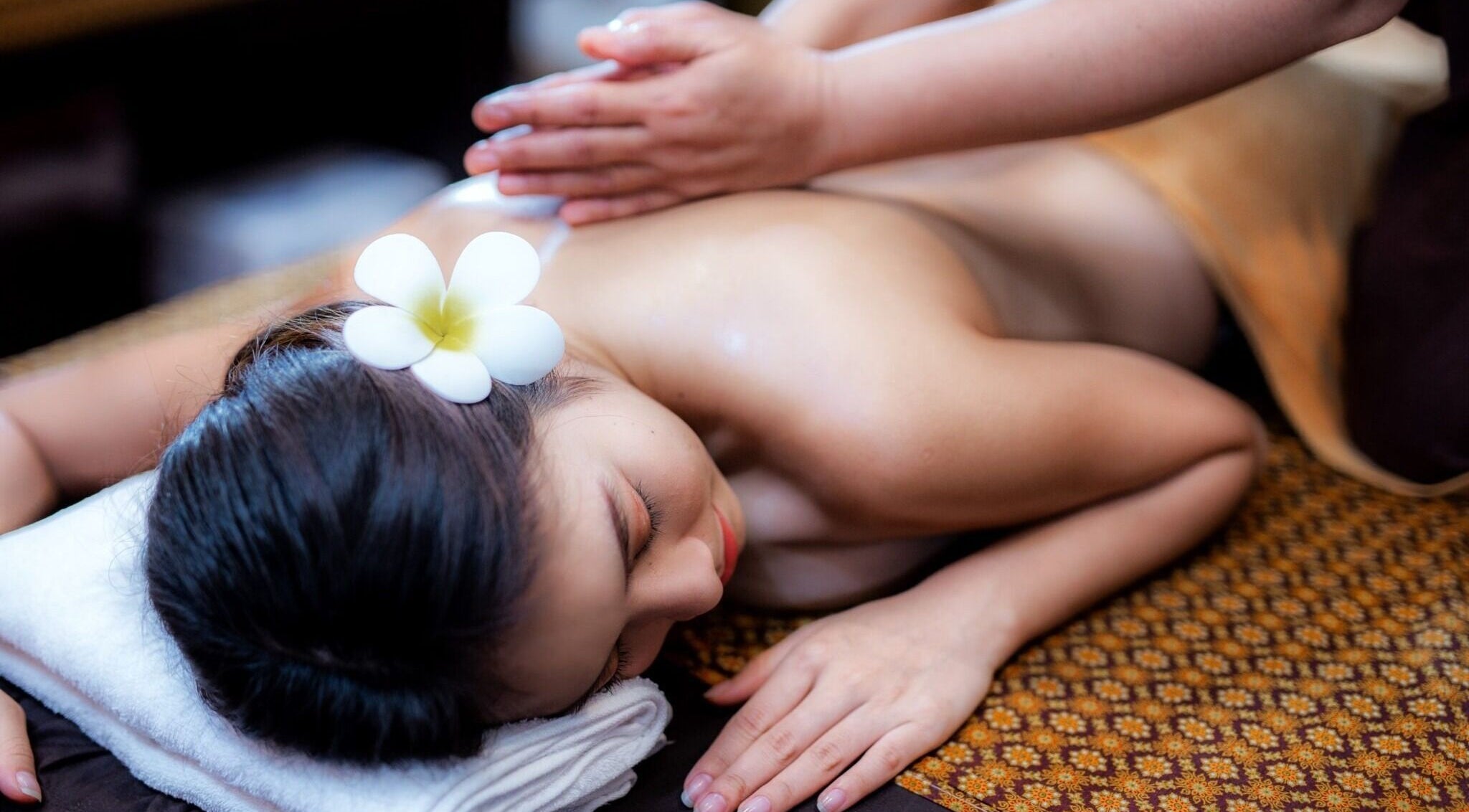 Ontspannen lichaamsmassage bij Weena Thai Massage Therapy, Gent, Vlaanderen, BE, met bloem op hoofd.