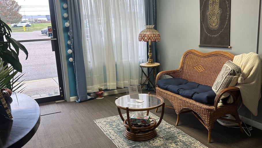 Inviting seating area at Sleepy Koi Bodyworks, Swartz Creek, Michigan, US with wicker chair and elegant decor.