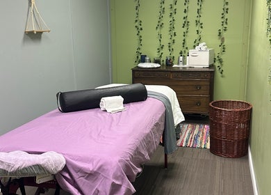 Relaxing massage room at Sleepy Koi Bodyworks in Swartz Creek, Michigan, US with calming green walls.