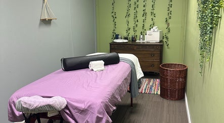 Relaxing massage room at Sleepy Koi Bodyworks in Swartz Creek, Michigan, US with calming green walls.
