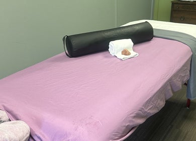 Massage table at Sleepy Koi Bodyworks in Swartz Creek, Michigan, US with soothing decor and cozy linens.