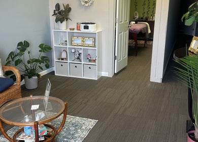 Tranquil waiting area at Sleepy Koi Bodyworks, Swartz Creek, Michigan, US, with cozy seating and lush plants.