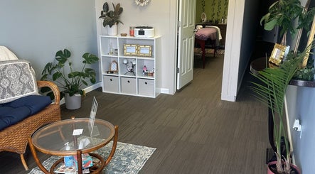 Tranquil waiting area at Sleepy Koi Bodyworks, Swartz Creek, Michigan, US, with cozy seating and lush plants.
