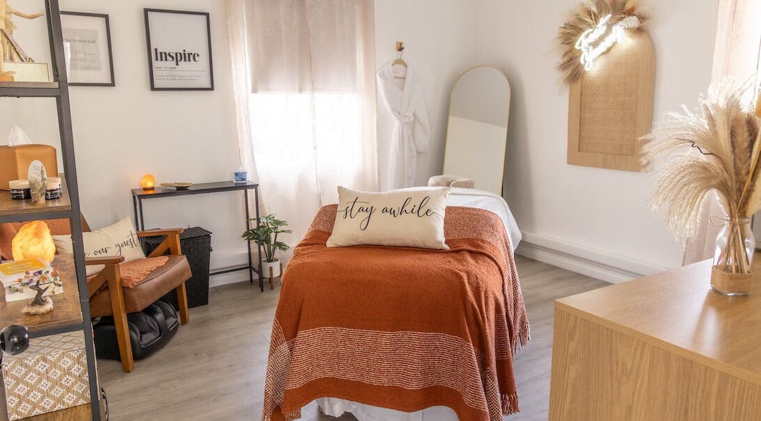 Relaxing treatment room at Vanity Artistry in Winter Park, Florida, US with a plush bed and soft decor.