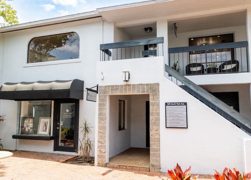 Exterior of Vanity Artistry in Winter Park, Florida, US featuring a modern white building with large windows.