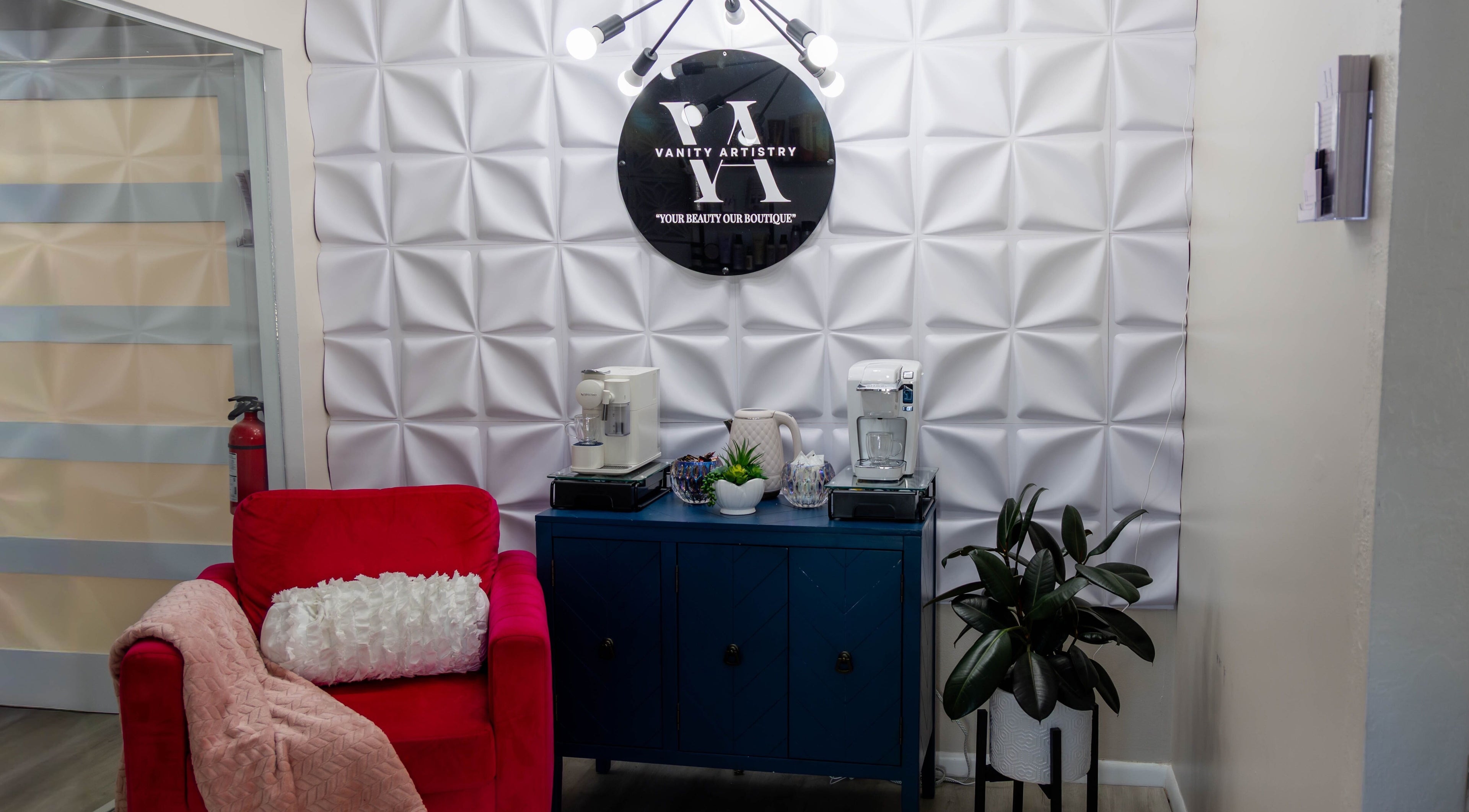 Elegant seating area at Vanity Artistry, Winter Park, Florida, US with red chair and modern decor.