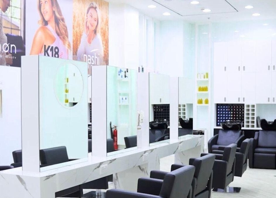 Contemporary salon interior at Hair Colosseum Beauty Salon, Dubai, AE, featuring sleek styling chairs and mirrors.