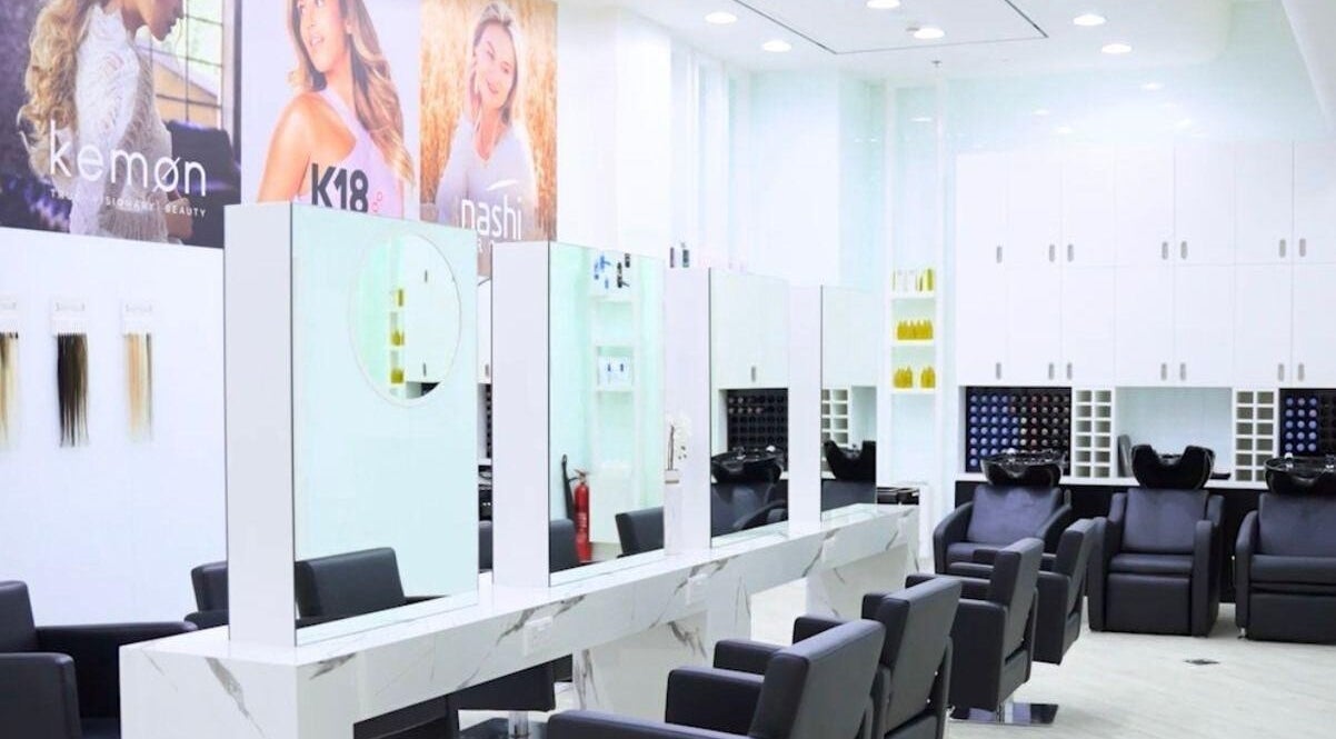 Contemporary salon interior at Hair Colosseum Beauty Salon, Dubai, AE, featuring sleek styling chairs and mirrors.