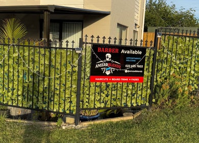 Barber shop sign at Amzadblendz in Auckland, NZ, highlighting services like haircuts and beard trims.