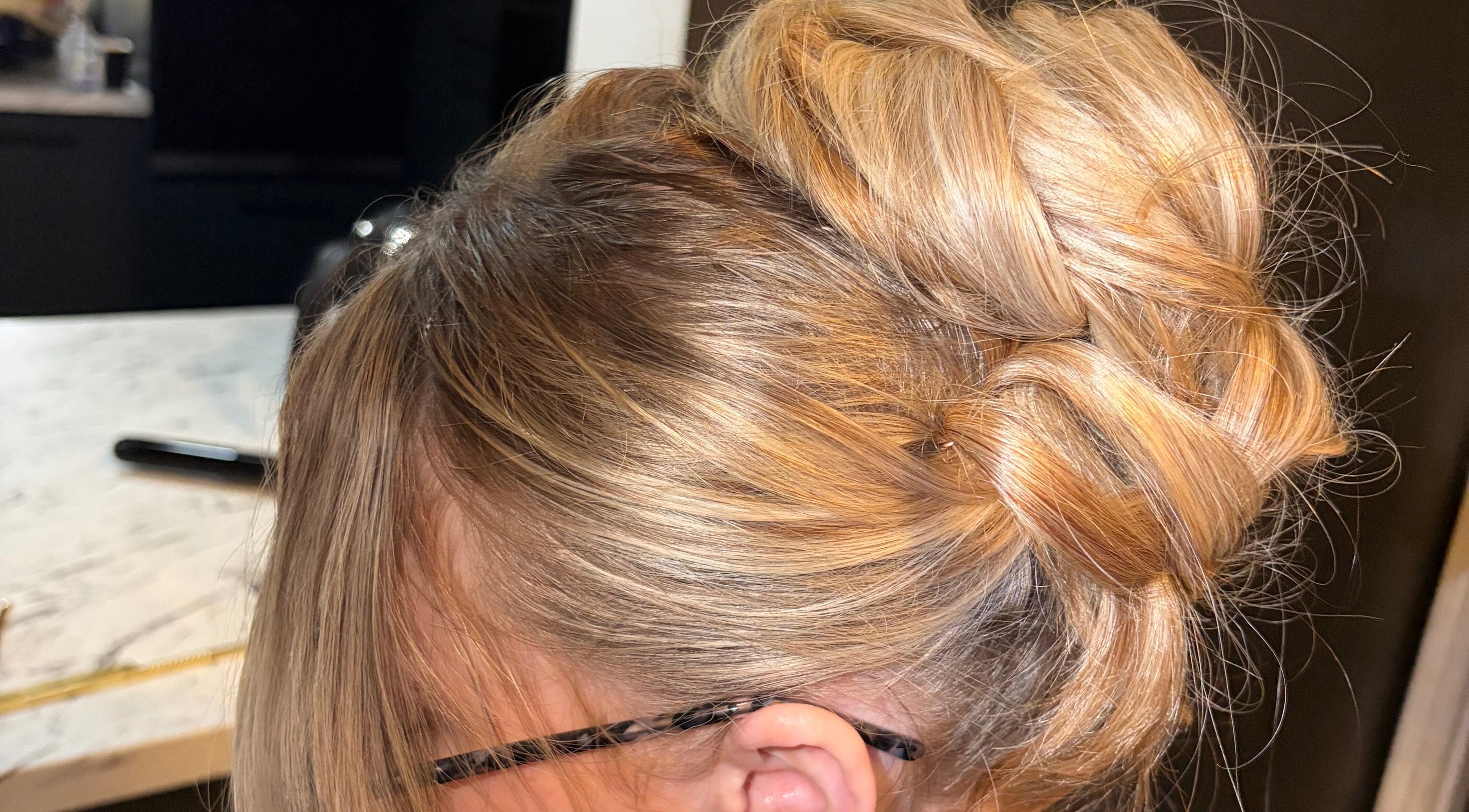 Elegant blonde updo hairstyle at Defined By Tiaalisha in Egremont, England.
