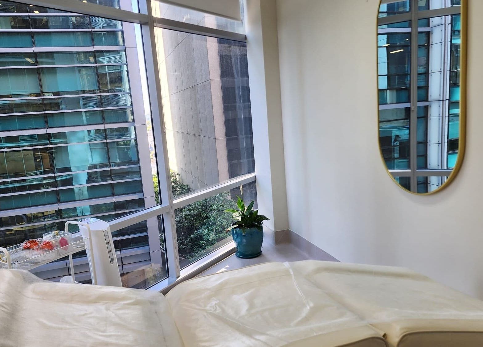 Serene treatment room at Glow Body & Mind in North Sydney, New South Wales, AU with a city view.
