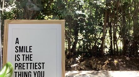 Cartel motivador en Smileclinic, Buenos Aires, Ciudad Autónoma De Buenos Aires, AR, entre árboles verdes.