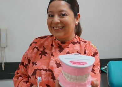 Dentista en Smileclinic Buenos Aires enseñando higiene oral con modelo dental.