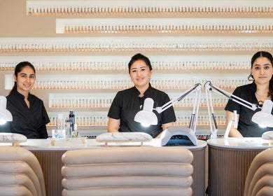 Three professional nail technicians at Mèye, Montréal, Québec, CA, ready to serve at a chic manicure station.