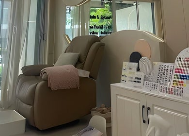 A cozy pedicure chair at Diva Nailslash, Krung Thep Maha Nakhon, with nail color samples displayed.