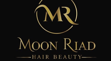 Logo dorato di MOONRIAD HairBeauty, Castelverde, Lombardia, IT, su sfondo nero elegante.