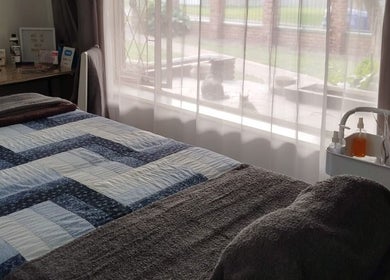 Cozy treatment room at Mekyla Wellness, Gqeberha, Eastern Cape, ZA, featuring a neatly made bed and gentle lighting.