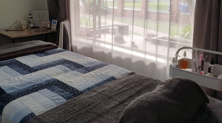 Cozy treatment room at Mekyla Wellness, Gqeberha, Eastern Cape, ZA, featuring a neatly made bed and gentle lighting.