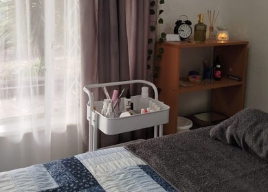 Relaxing treatment room at Mekyla Wellness in Gqeberha, Eastern Cape, ZA, featuring cozy bed and products.