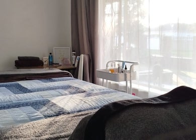 Cozy massage beds at Mekyla Wellness in Gqeberha, Eastern Cape, ZA, sunlight filtering through sheer curtains.