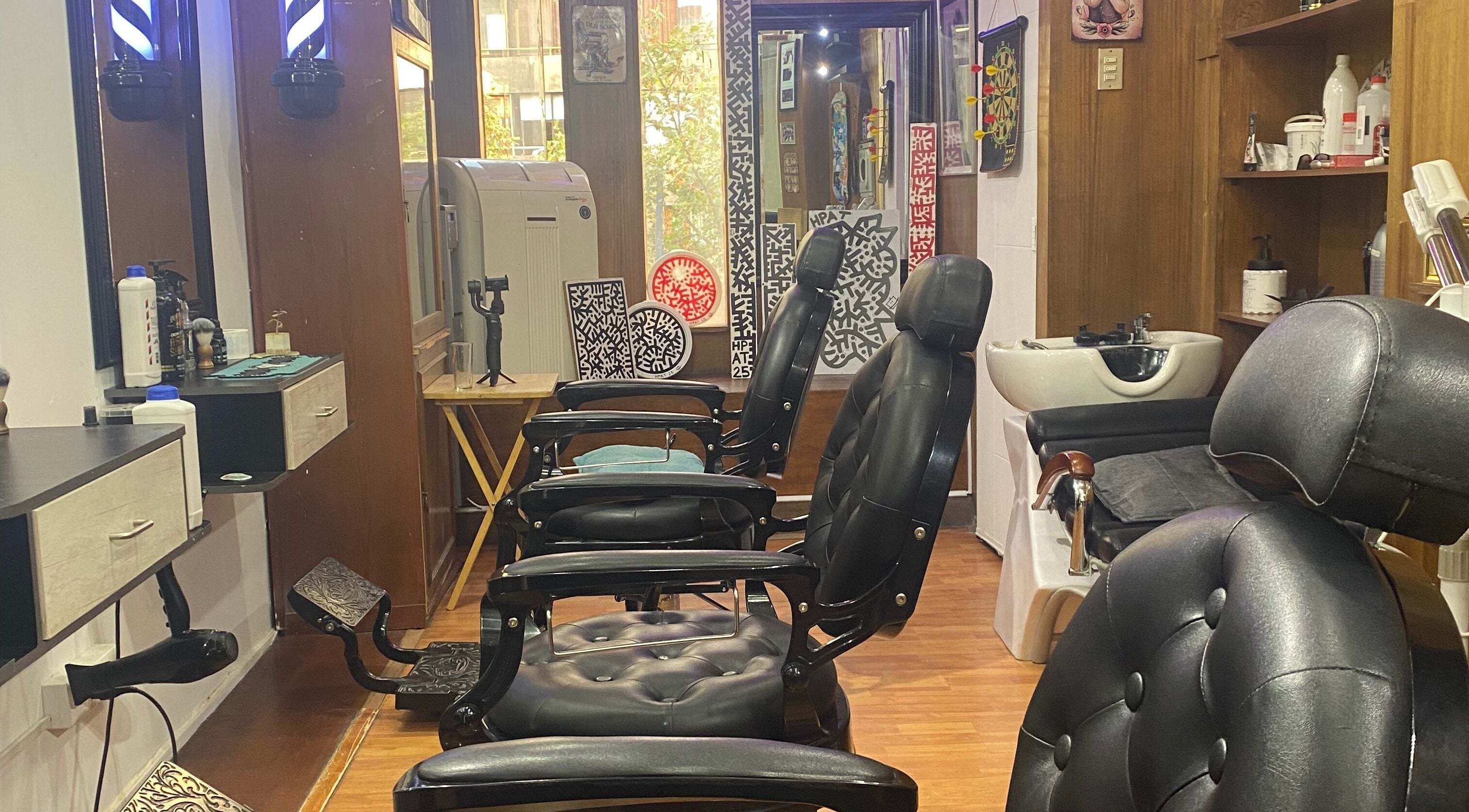 Interior de The Cut Barbería Social Club en Providencia, Región Metropolitana, CL con sillas y decoración moderna.