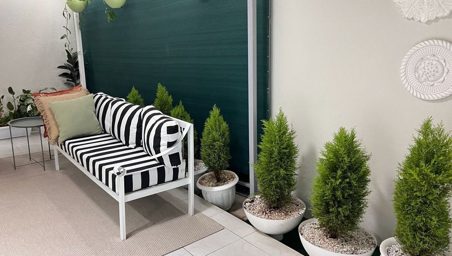 Stylish seating area at Papaya Wellness, Nairobi with striped cushions and potted plants.
