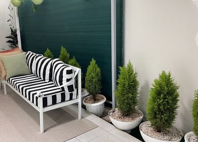 Stylish seating area at Papaya Wellness, Nairobi with striped cushions and potted plants.