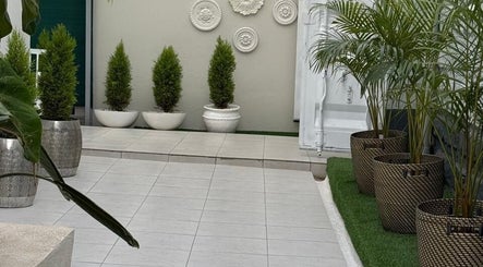 Elegant green patio at Papaya Wellness, Nairobi, Nairobi County, KE, with potted plants and decorative wall art.